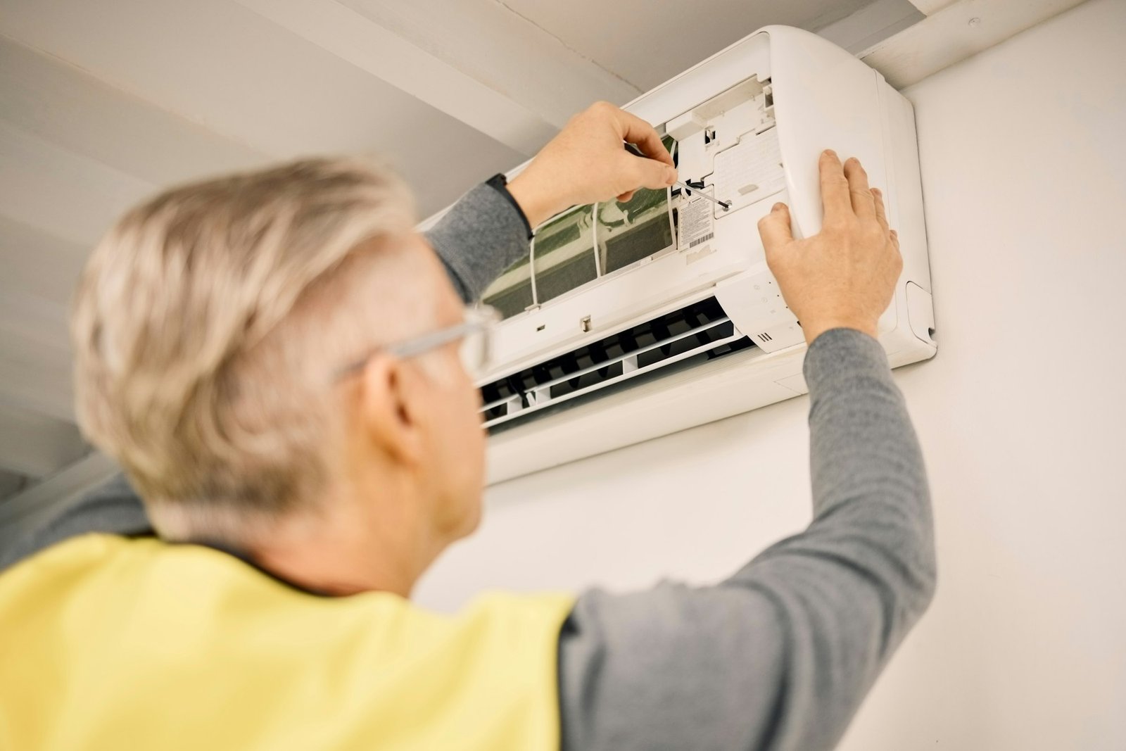 Maintenance, installation and back of a man with air conditioner for service and ac repair. Buildin